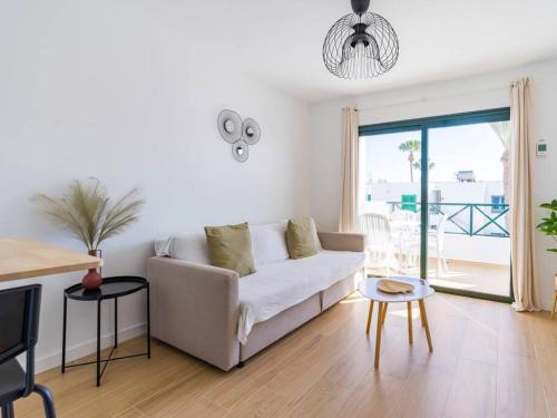 uma sala de estar branca com um sofá e uma mesa em Apartamento Dara - Apartamento con piscina em Tías