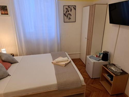 ein Schlafzimmer mit einem Bett und einem TV in der Unterkunft Maria's Place in Korčula