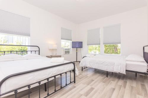 2 bedden in een witte kamer met ramen bij Home Downtown Miami - Wynwood Area & Port - Art District near Beach in Miami