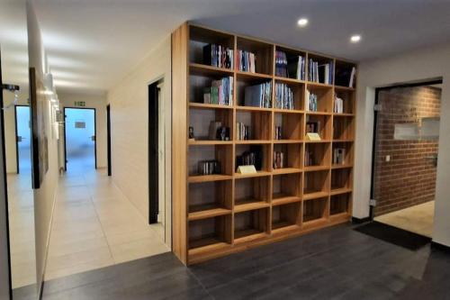 a library with wooden shelves filled with books at Sauna, Pools mit XXL-Terasse oder Kinderkino in Sankt Englmar