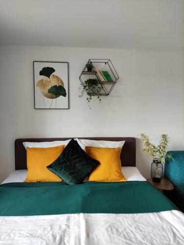 a bed with green and yellow pillows on it at Sauna, Pools mit XXL-Terasse oder Kinderkino in Sankt Englmar