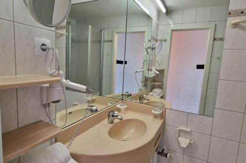a bathroom with a sink and a mirror at Sauna, Pools mit XXL-Terasse oder Kinderkino in Sankt Englmar