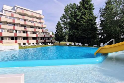 uma piscina com escorrega em frente a um edifício em Sauna, Pools und XXL-Terasse em Sankt Englmar