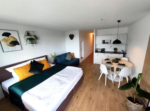a bedroom with a large bed and a dining room at Sauna, Pools mit XXL-Terasse oder Kinderkino in Sankt Englmar
