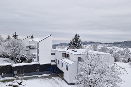 a white house in the snow with trees at Sauna, Pools mit XXL-Terasse oder Kinderkino in Sankt Englmar