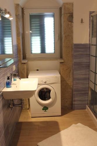 a bathroom with a washing machine and a sink at Appartamento Le Tre Palme in Frigintini