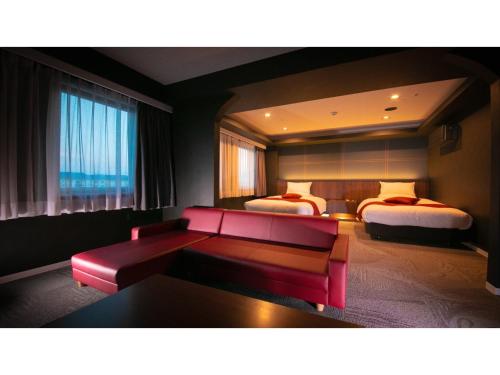 a hotel room with a couch and two beds at Hotel Satsukien - Vacation STAY 75962v in Kanoya