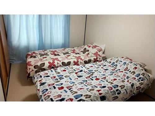 ein Bett mit einer Bettdecke und Kissen darauf in der Unterkunft Corpo Marika 0 - Vacation STAY 81260v in Hakodate