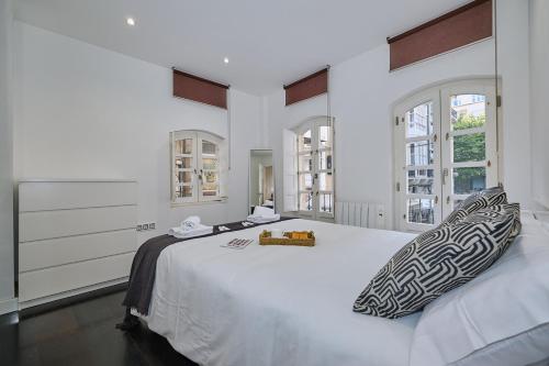 1 dormitorio blanco con 1 cama blanca grande con almohadas en Galera51 by Serendipia Turismo en A Coruña
