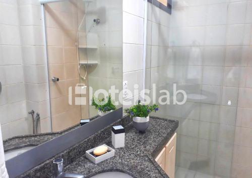 La salle de bains est pourvue d'un lavabo et d'une douche en verre. dans l'établissement Lindo apartamento com vista para o mar em Canasvieiras C108, à Florianópolis