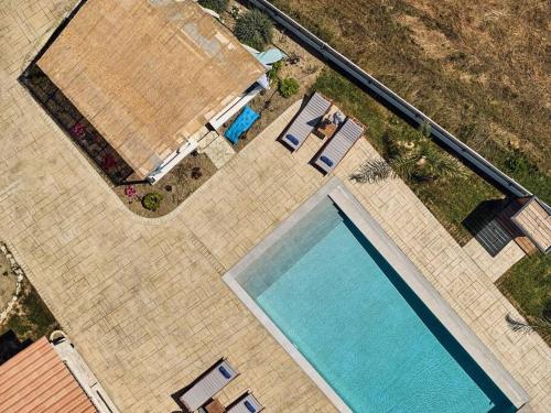 an overhead view of a swimming pool with chairs at Villa Arianna, close to the beach! in Kalamaki