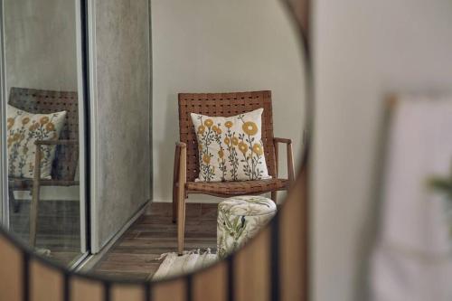 a reflection of a chair in a mirror at Villa Arianna, close to the beach! in Kalamaki