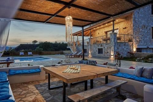 a large patio with a table and a pool at Villa Arianna, close to the beach! in Kalamaki
