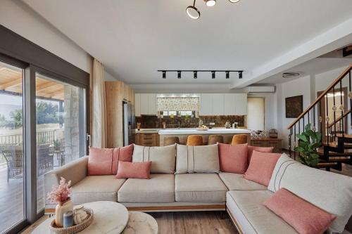 a living room with a couch with pink pillows at Villa Arianna, close to the beach! in Kalamaki