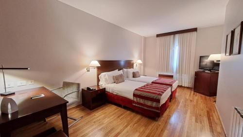 a hotel room with a bed and a desk at Hotel Del Comahue in Neuquén