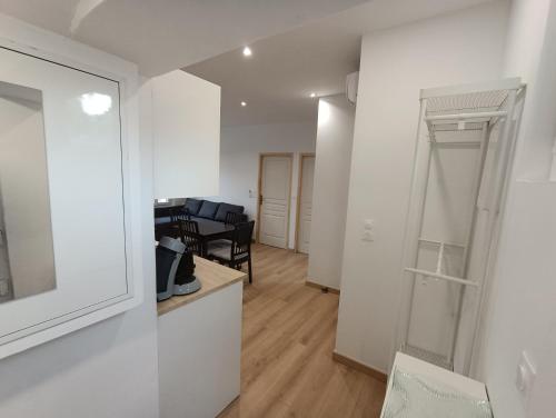 Cette chambre blanche dispose d'un miroir et d'une table. dans l'établissement T3 rénové en 2023, Intra muros Avignon, à Avignon