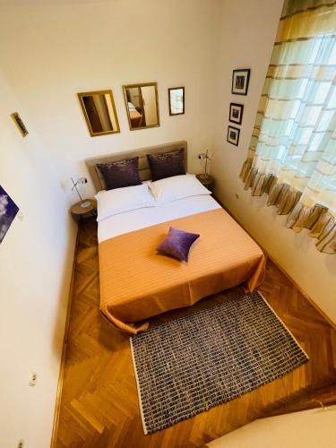 Dormitorio pequeño con cama y alfombra en Peace Sea View Apartment, en Makarska