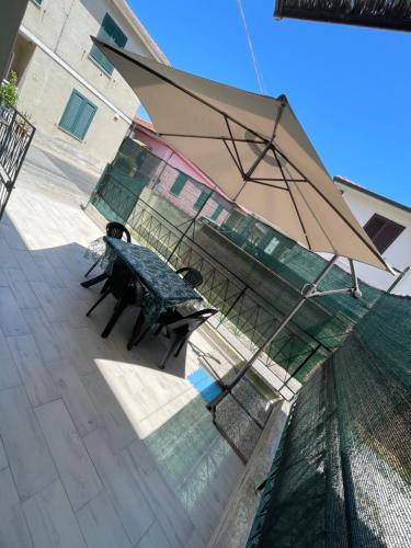 a picnic table with an umbrella on a patio at Appartamento a 400mt dal mare in Cecina