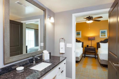 a bathroom with a sink and a mirror at WorldMark Orlando Kingstown Reef in Orlando