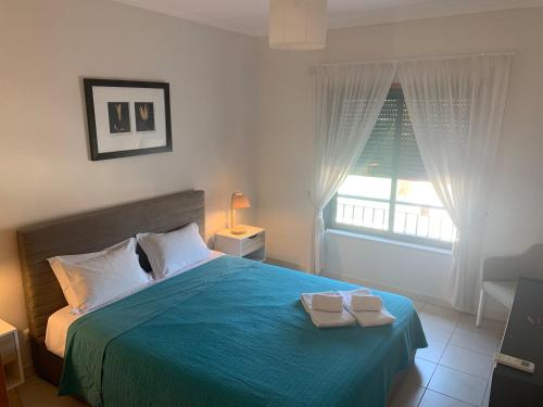 ein Schlafzimmer mit einem blauen Bett mit zwei Handtüchern darauf in der Unterkunft Vista das Ondas - AP in Albufeira