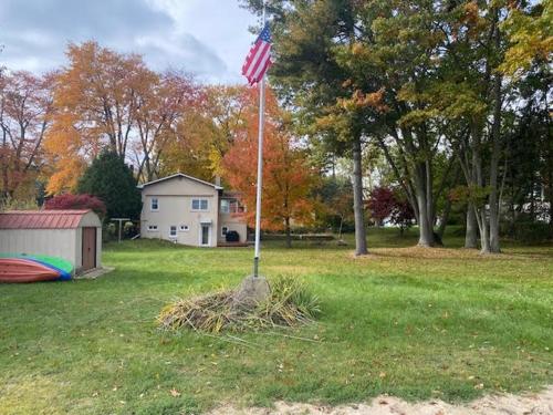Un poste con una bandera americana en un patio en Amazing Lakefront Retreat On Long Lake! home, en Portage