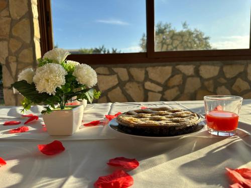 a table with a pie and a vase of flowers at Villa Tuscia apartments in Tuscania