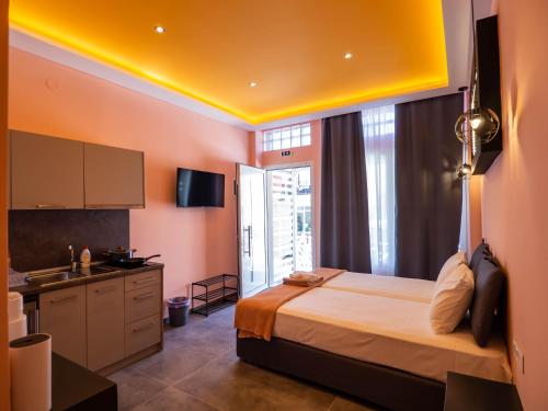 a bedroom with a bed and a kitchen with a sink at ThassCities Casa Studios in Limenas