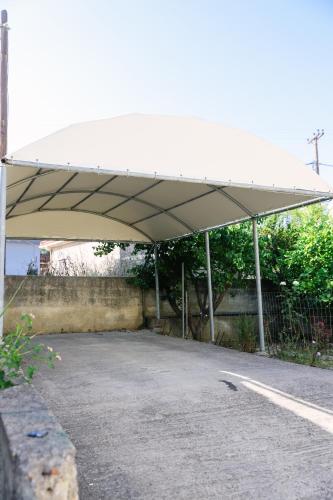 a canopy over a parking lot with a road at Nous Dios in Xilokéra