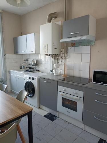 a kitchen with white cabinets and a washer and dryer at Centre in Brest