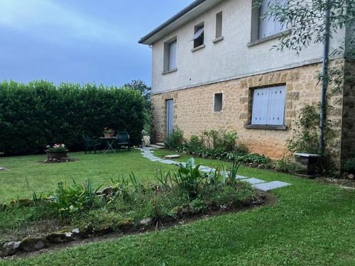 a house with a yard with a table and a patio at La Chambre a l'Oree du bois in Capdrot