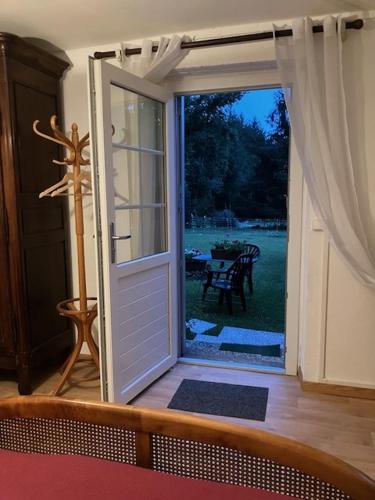 an open door with a view of a yard at La Chambre a l'Oree du bois in Capdrot