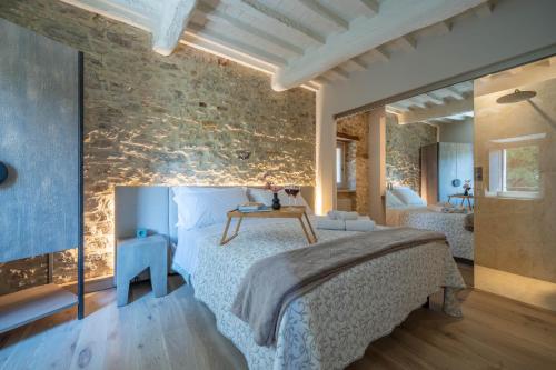 a bedroom with a bed and a stone wall at Forma Your Boutique Suite in Corciano