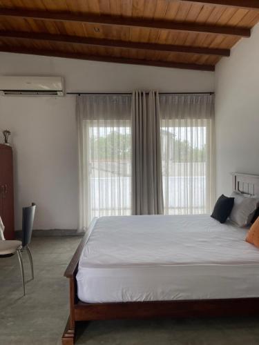 a bedroom with a large bed and a large window at Colombo Residency -Pent House in Kotuwegoda