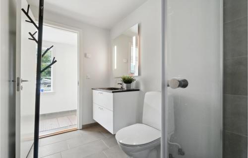 a white bathroom with a toilet and a sink at 1 Bedroom Amazing Apartment In Rnne in Rønne