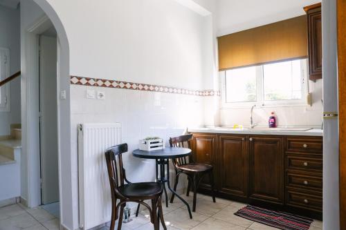 a kitchen with a table and chairs and a sink at Nous Dios in Xilokéra