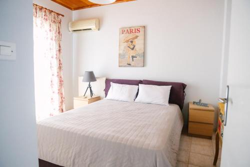 a bedroom with a white bed and a window at Nous Dios in Xilokéra