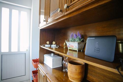 a kitchen counter with a laptop on a wooden shelf at Nous Dios in Xilokéra