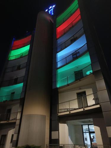 a tall building with colorful windows at night at Green Hotel Ninfa in Avigliana