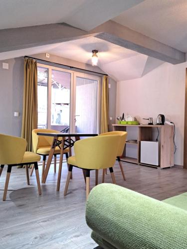a living room with a table and yellow chairs at Papi Apartments in Kruševo