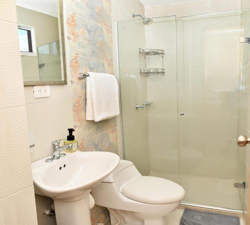een badkamer met een toilet, een wastafel en een douche bij De estreno, nuevo apto en Barranquilla in Barranquilla