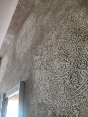 a wall with a silver design on it at Grotta dei Puntali B&B in Carini