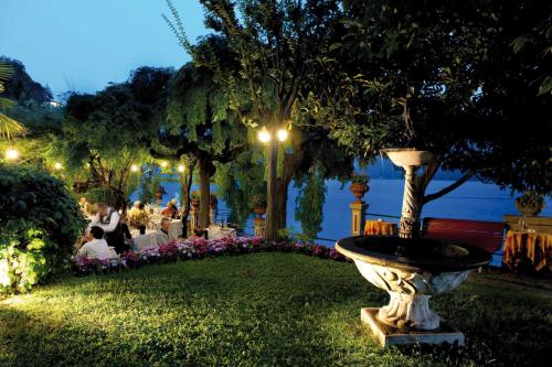 a fountain in the middle of a park at night at Hotel Stella D'Italia in Valsolda