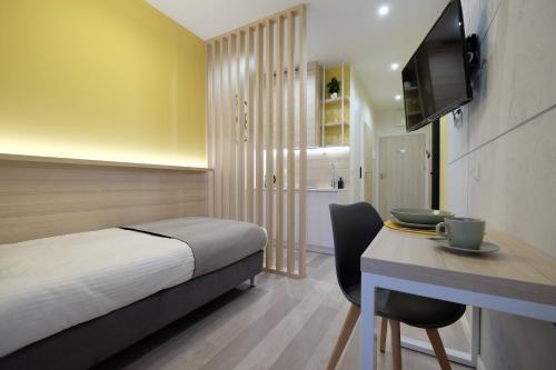 a hotel room with a bed and a desk and a television at Apartamenty Centrum in Białystok