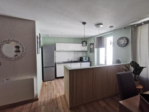 a kitchen with a refrigerator and a counter top at Maison de ville le 101 - 3 chambres - garage in Angoulême