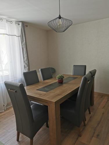 a dining room table with chairs and a table and a light fixture at Maison de ville le 101 - 3 chambres - garage in Angoulême