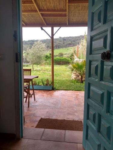 een deur naar een patio met een tafel en uitzicht bij Casita La Raiz in Barbate