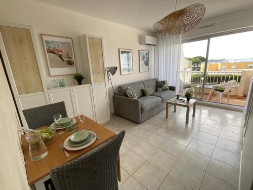 un salon avec une table et un canapé dans l'établissement Studio le Vue mer Accès direct à la plage Parking privé Clim belle terrasse, au Grau-du-Roi