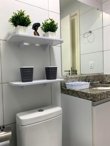 ein Badezimmer mit Toilette, Waschbecken und Spiegel in der Unterkunft Flat Muro Alto Porto de Galinhas in Porto De Galinhas