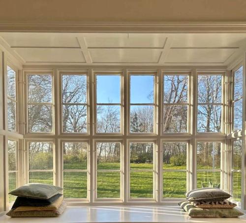 a large room with a large window with pillows at Bellinge House in Horreby