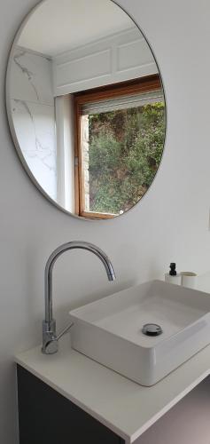 ein Badezimmer mit einem Spiegel über einem weißen Waschbecken in der Unterkunft D'Hestia - Gîte avec vue imprenable sur Huy in Huy